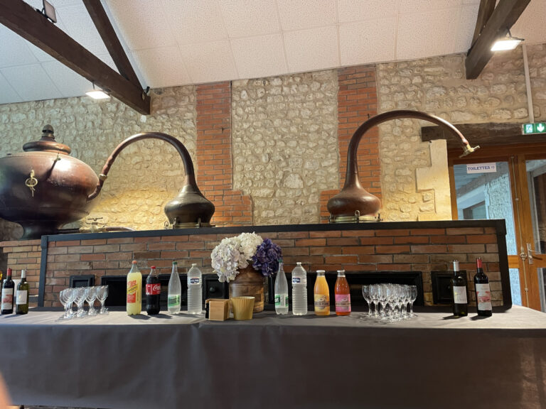 Boissons sur une table devant les alambics de la salle des Vieux Chais.